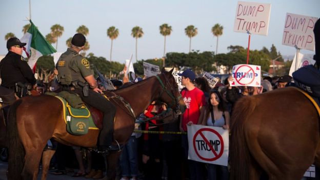 Полиция держит назад оппонентов козыря в Costa Mesa, Калифорния, 28-ое апреля