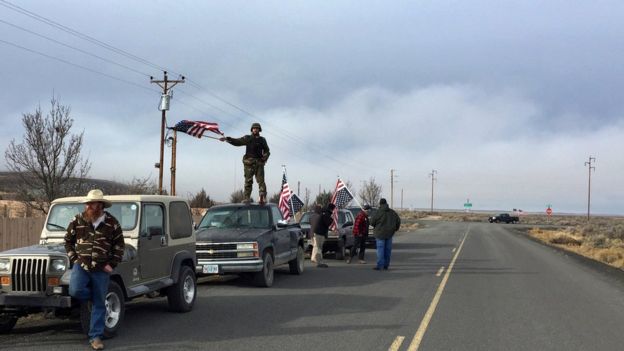 Люди развевают флаги США около убежища Malheur